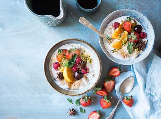 Inspirerande frukostbild tagen uppifrån på två skålar med yoghurt och frukt.