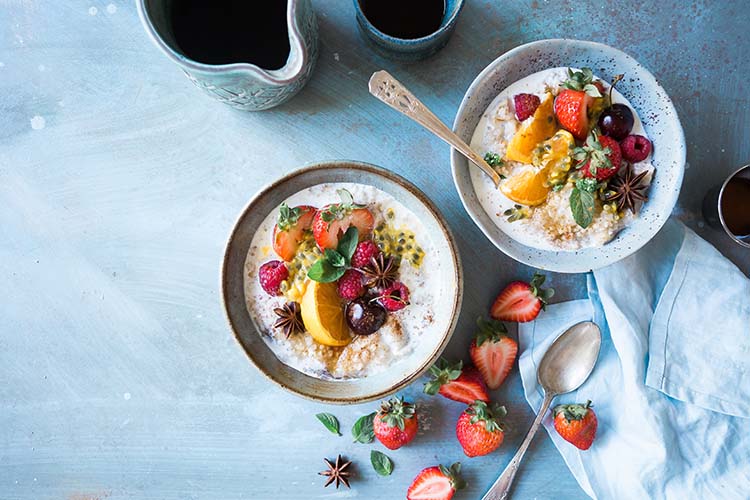 Inspirerande frukostbild tagen uppifrån på två skålar med yoghurt och frukt.