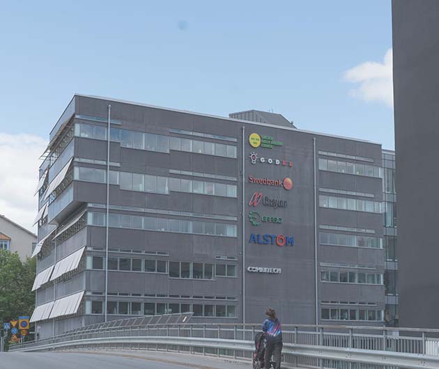 Fasaden på en grå kontorsfastighet på vilken man ser flera företagsloggor, däribland EFFSOs.