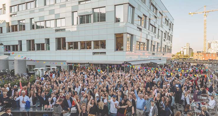 Fest utomhus med väldigt mycket folk, i bakgrunden syns ett kontorshus och längst bort en byggkran.