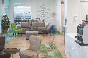 Ett hem trevligt kontor som i första anblick ser tomt ut, men man anar konturerna av en person som går mot kameran.