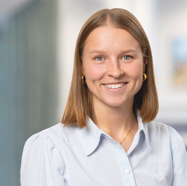 Rebecca Nygård citat Inomhusporträtt på en yngre kvinna i ljusblå skjorta.
