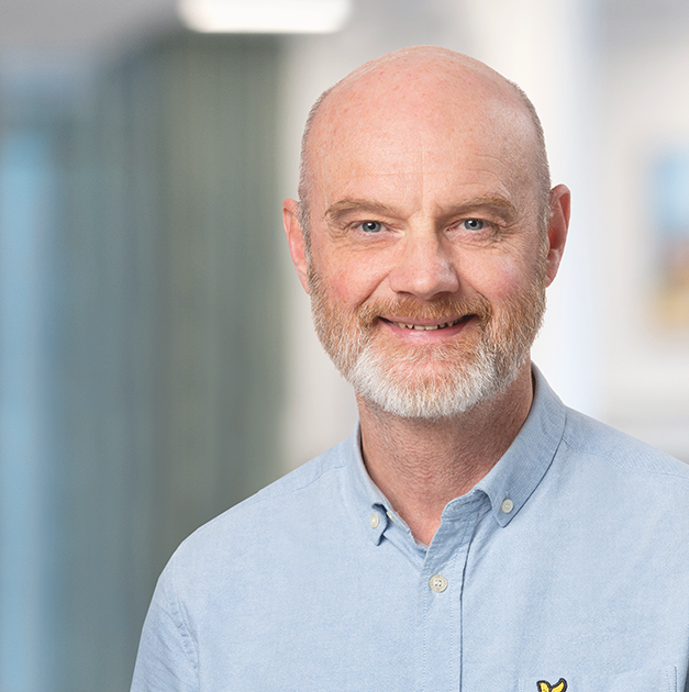 Christer Wranå citat Porträtt på äldre man i kort vitt skägg och ljsublå skjorta som ser in i kameran och ler.