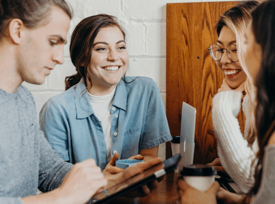 Fyra studenter sitter och arbetar i grupp.