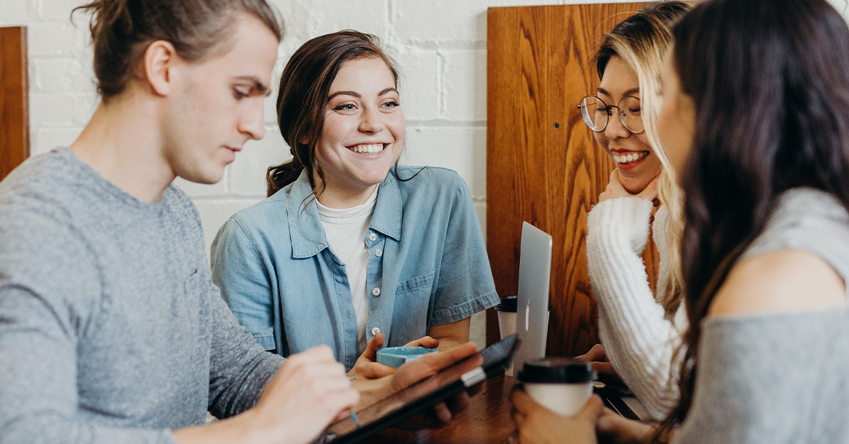 Fyra studenter sitter och arbetar i grupp.