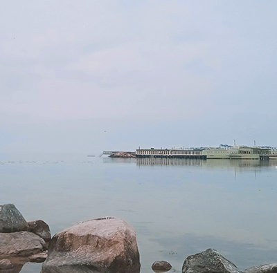 Bild tagen från vattnet på Turning Torso i Malmö i svag dimma.