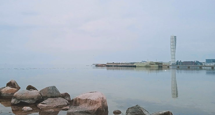 Bild tagen från vattnet på Turning Torso i Malmö i svag dimma.
