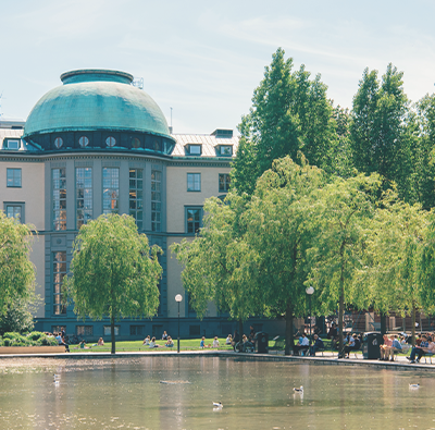 Bild på ena fasaden av Handelshögskolan i Stockholm,d en som vetter ut mot dammen.